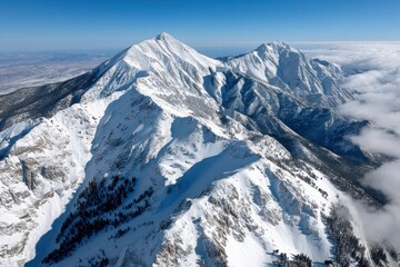 Snow-covered mountain range under clear blue sky showcasing majestic peaks in a winter landscape