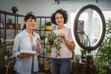 two woman use mobile phone for live stream about care home plants