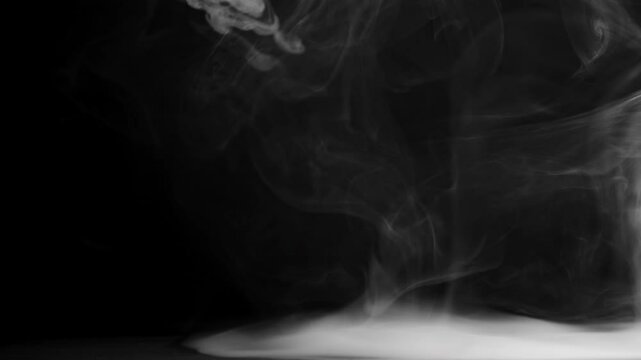 Abstract slow motion shot of white smoke in slow motion, fog in light spot background. Slow motion