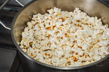 Ready Popcorn in stainless steel pot made in home kitchen on stove top