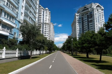 Modern high-rise buildings in the city on a sunny day, with a blue sky, grass on both sides of the road