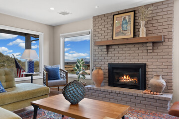A cozy living room featuring a warm fireplace and a spacious, large window