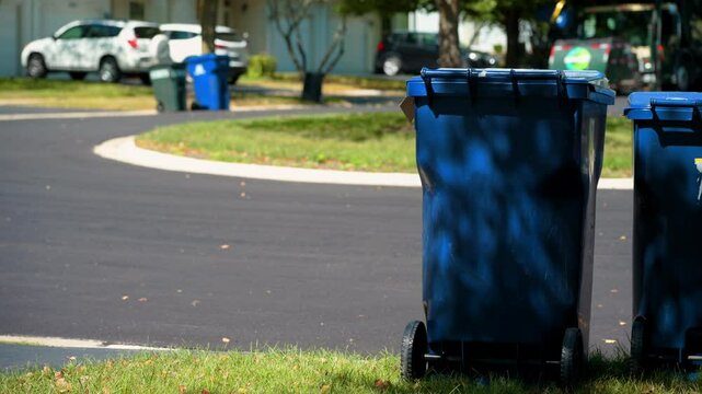 Garbage truck unloading a garbage can at sunny day. Middle shot view