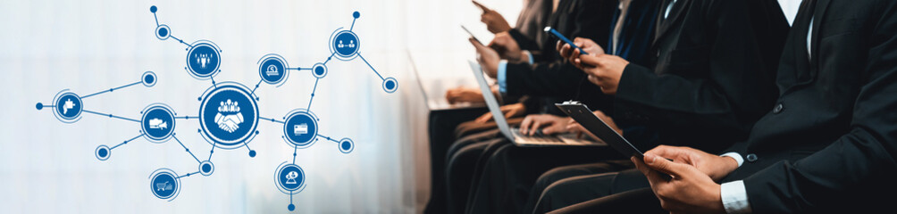 Business professionals interact with digital devices in a modern corporate space, illustrating the importance of technology and networking in the contemporary workplace. Amity