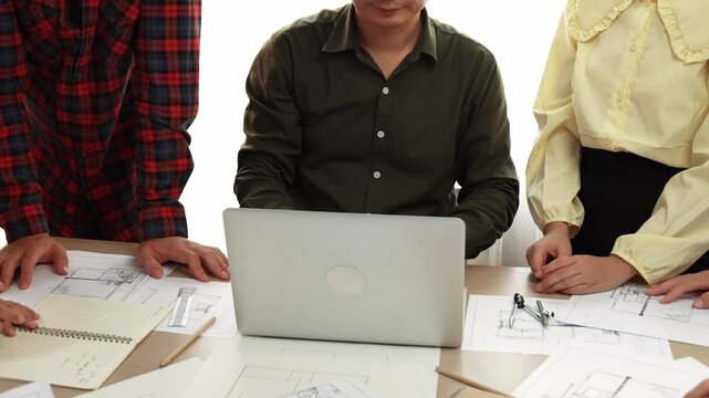 Smart architect and safety engineer discussion about building plan on table with architectural document, measurement tools and wooden block scatter around at modern office. Closeup. Delineation.