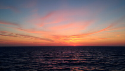 Fototapeta premium sun is setting over the ocean as seen from a boat