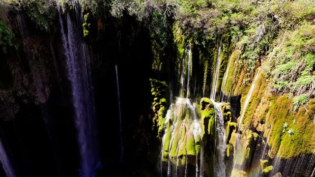 Yerkopru waterfall streaming down moss-covered rocks, displaying verdant landscape within lush natural setting of mersin province, turkey