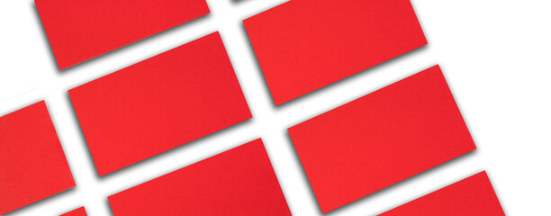 Mockup of horizontal red business cards stacks arranged in rows at white textured paper background. Banner.