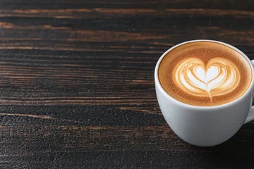A cup of coffee with latte art on a wooden table.