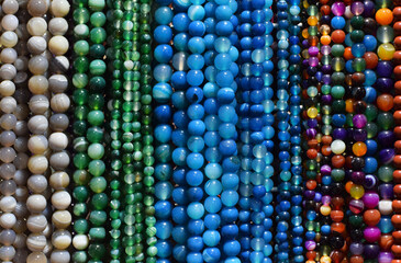Strands of colorful natural agate beads at the gemstone market.