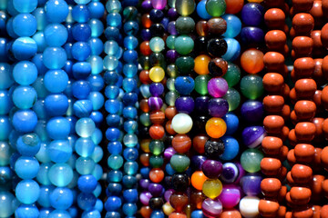 Strands of colorful natural agate beads at the gemstone market.