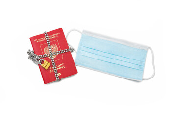 Passport with a medical mask on a white background.