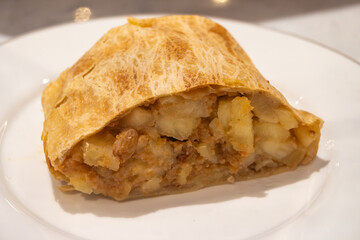 Austrian desserts, piece of apple strudel without whipped cream to be served in old traditional bakery cafe in Vienna, close up