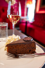 Piece of famous Sachertorte chocolate cake with apricot jam of Austrian origin served with whipped...
