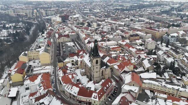 Aerial drone view of a picturesque Czech town with red rooftops and a grand snow-covered cathedral. Winter charm, historic architecture, and scenic beauty&mdash;perfect for travel or holiday themes.