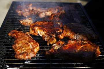 Juicy steaks sizzling on an outdoor grill. Smoky flavor, open fire, and perfect sear—authentic barbecue in nature. Great for food, camping, and outdoor cooking themes.