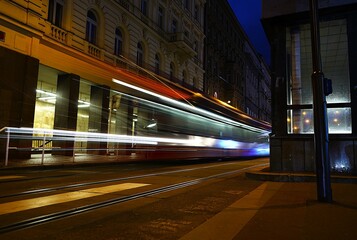 Fototapeta premium Tram moving through city streets—urban transport, dynamic rhythm, and daily life in motion. Ideal for themes of public transit, city infrastructure, and modern commuting.