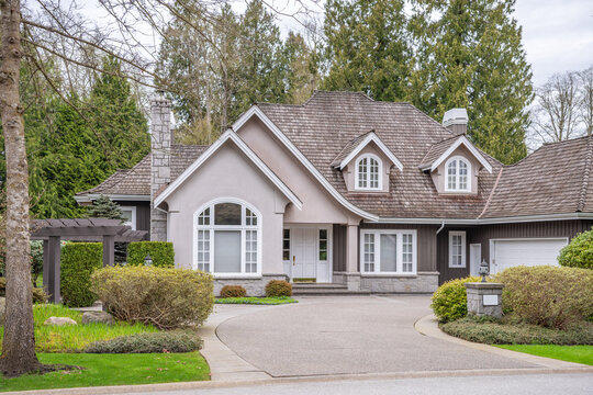 Two story stucco luxury house with nice spring blossom landscape in Vancouver, Canada, North America. Day time on April 2025.