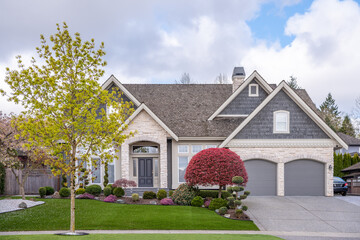 Two story stucco luxury house with nice spring blossom landscape in Vancouver, Canada, North...