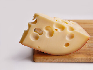 cheese with big holes on wooden cutting board, copy space