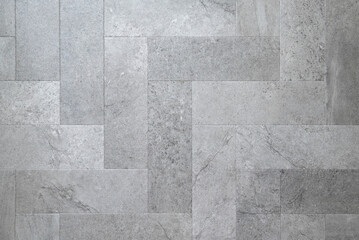 Gray stone rectangular tiles laid out in a herringbone floor