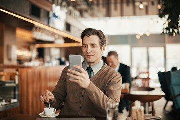 Confident businessman working remotely at coffee shop while drinking espresso