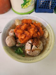 A bowl of flavorful bakso with pumpkin puree and meatballs.