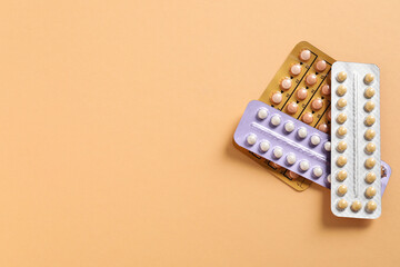 Blisters of contraceptive pills on beige background, top view. Space for text