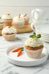 Delicious carrot cupcake with mint on white marble table
