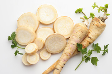 Parsley roots and leaves on white background, flat lay