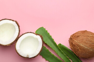 Hair treatment. Fresh coconut and aloe leaves on pink background, flat lay. Space for text