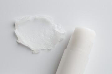 Stick of lip balm and sample on white background, top view