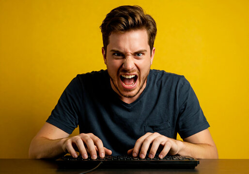 Angry man screaming at computer monitor while typing. Online haters and aggressive comments