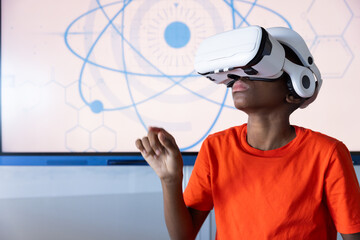 Using VR headset, student exploring virtual reality in school classroom