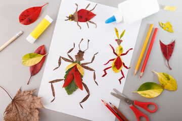 Handmade insect collages created from autumn leaves and paper on a grey background. Flat lay...