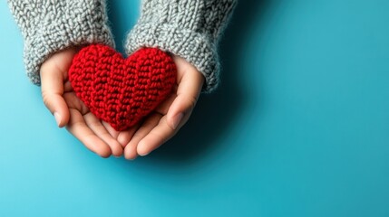 closeup of knitted red heart held in human hands wearing gray knitted sweater set against soothing blue background conveying themes of affection, support, and handcrafted love