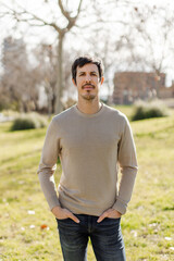 Portrait of a man with hands in pockets, neutral expression and direct gaze. Conveys confidence, authenticity, modern masculinity. Ideal Personal branding or lifestyle themes. Vertical, natural light