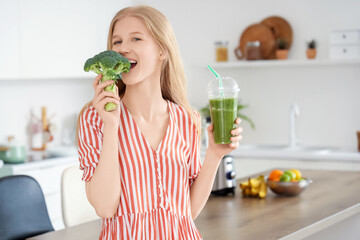 Young woman with healthy smoothie and broccoli in kitchen