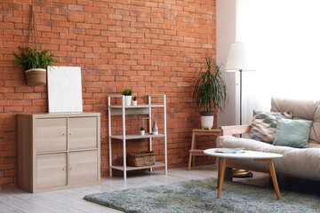 Interior of living room with cozy sofa, coffee table, chest of drawers and shelving units