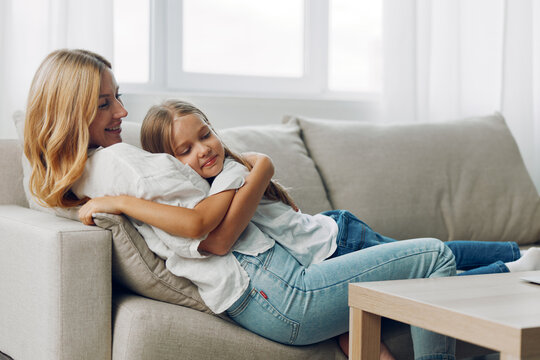 Mother and daughter share a special moment of love and closeness on the cozy sofa at home