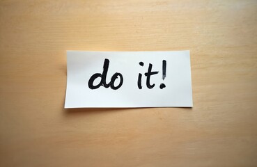 Simple handwritten message, motivational quote do it. written on white paper. Inspirational reminder for action on wood texture background. Concept of positive attitude, motivation, achievement.