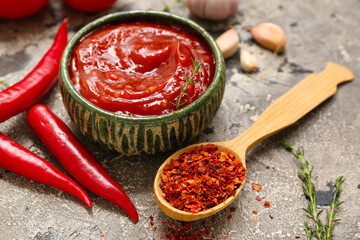 Bowl of chili sauce and different ingredients on grey background