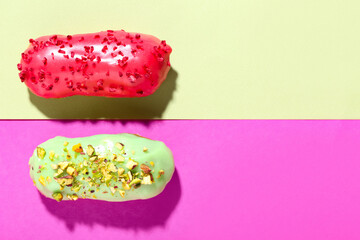 Delicious glazed eclairs on color background