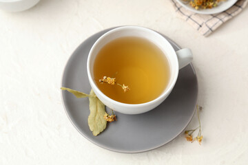 Cup of tasty linden tea on white background