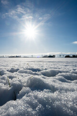 Obraz premium A field of snow with a bright sun shining on it