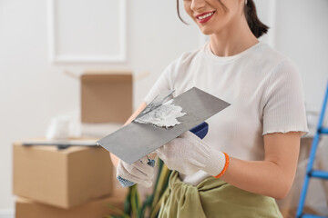 Young woman with putty knives in room, closeup