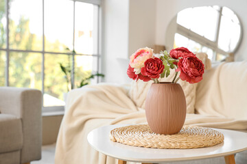 Vase with peony flowers on table in living room, closeup