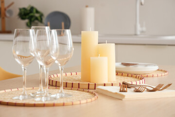Candles on tray and glasses on table in modern kitchen