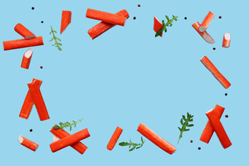 Frame made of tasty crab sticks with arugula leaves and peppercorns flying on blue background © Pixel-Shot