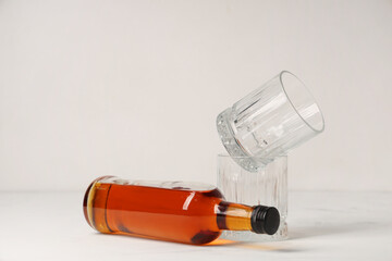 Bottle of rum and glasses on white background